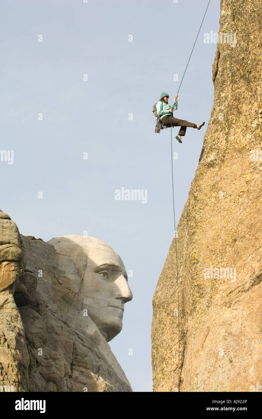 Woman rappelling rock face Stock Photo - Alamy