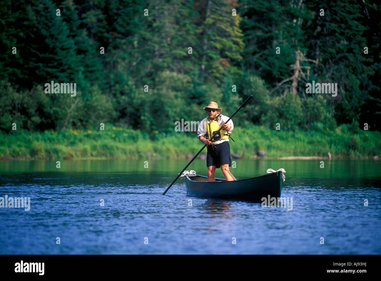Man displays the art of poling a canoe. Stock Photo