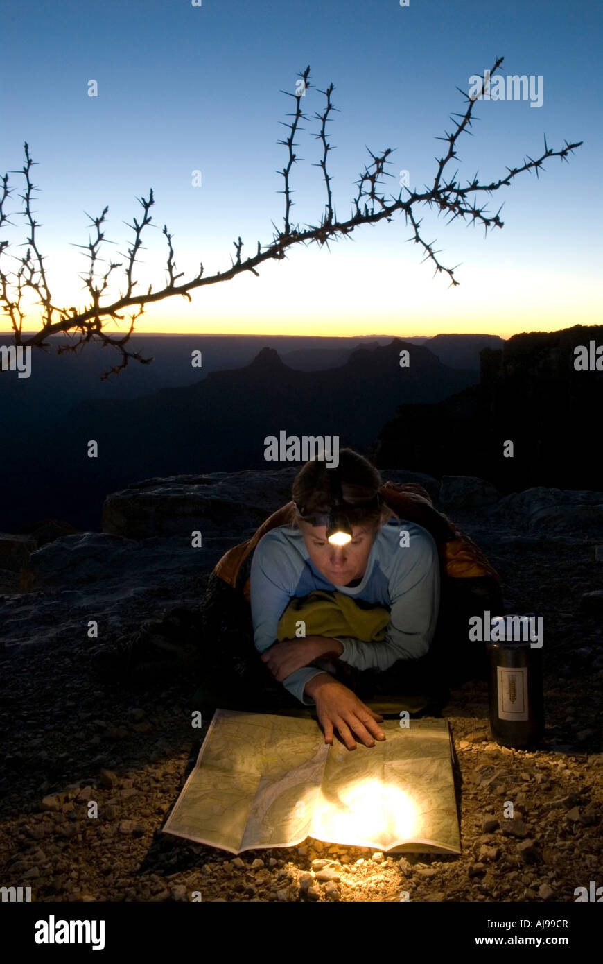 Woman reads map by headlamp. Stock Photo
