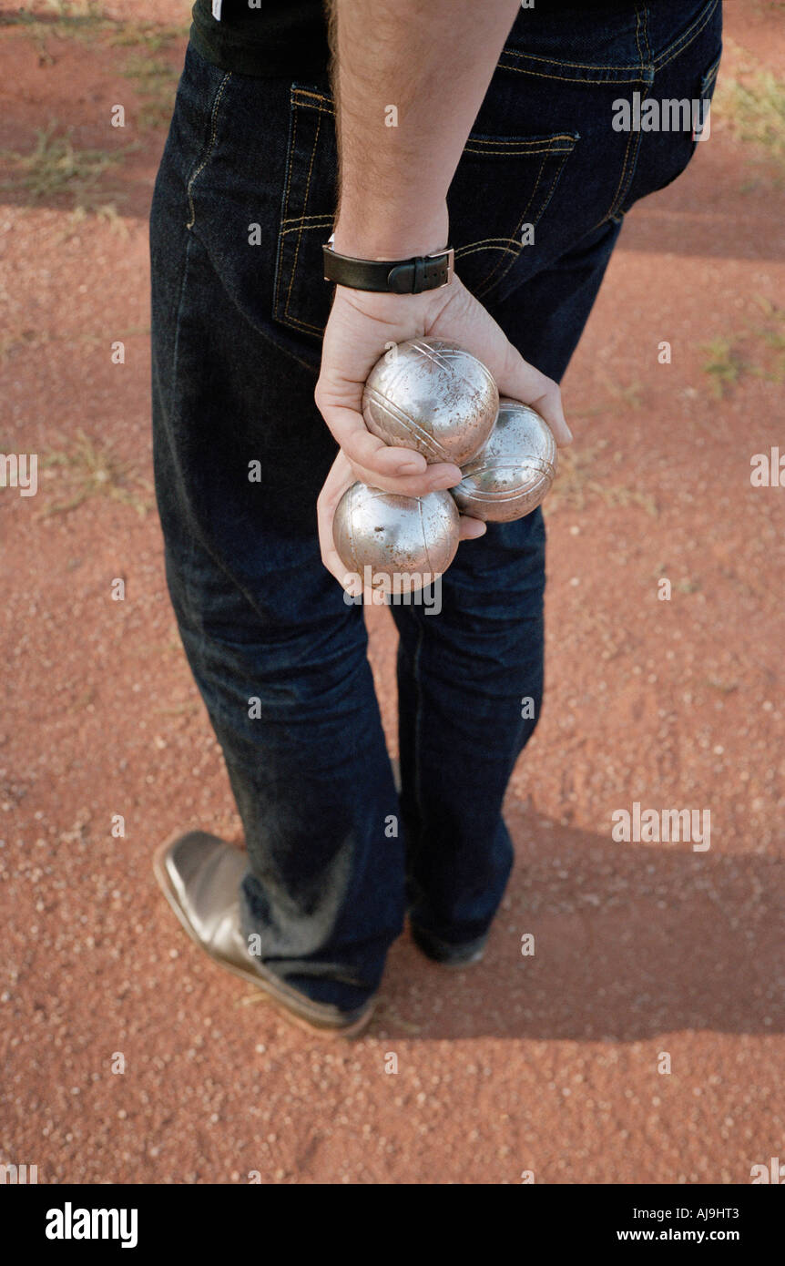 Man holding three bocce balls Stock Photo