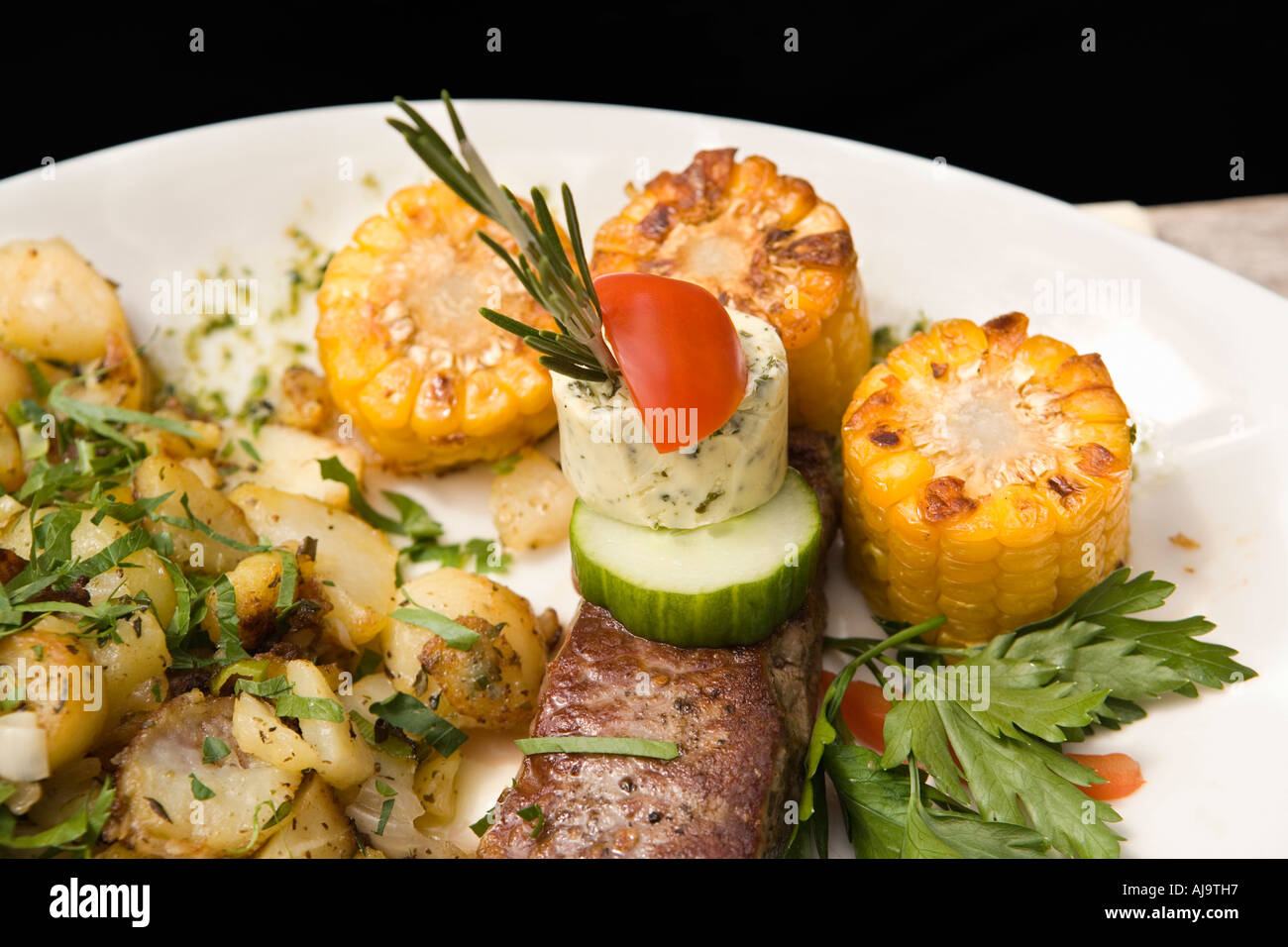 A rump steak with assorted vegetables on a plate Stock Photo