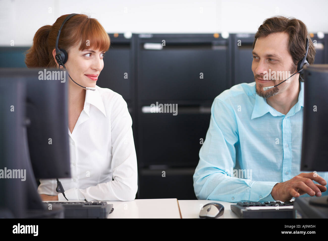 Business People Working on Computers with Headsets Stock Photo