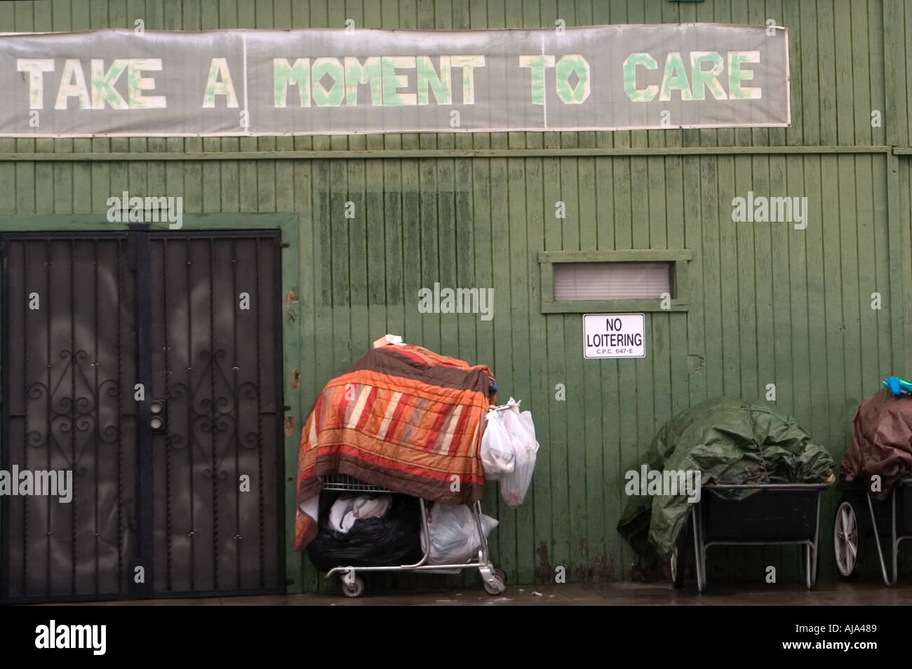 Shopping cart with homeless persons belongings on rain soaked street