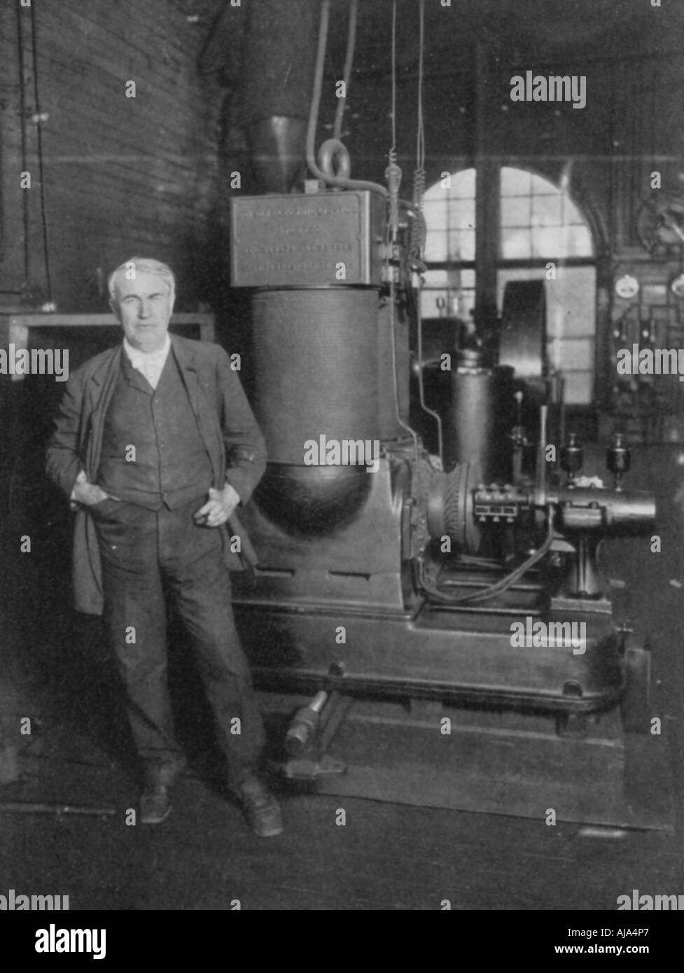 Thomas Alva Edison, American inventor, with his first dynamo for producing electric light, 1880s. Artist: Unknown Stock Photo