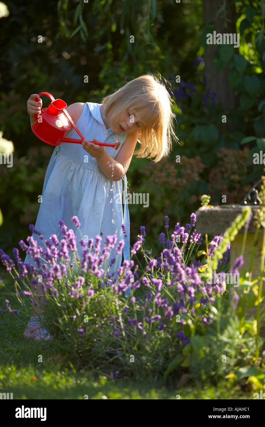 Young girl watering garden Dorset England UK Stock Photo Alamy