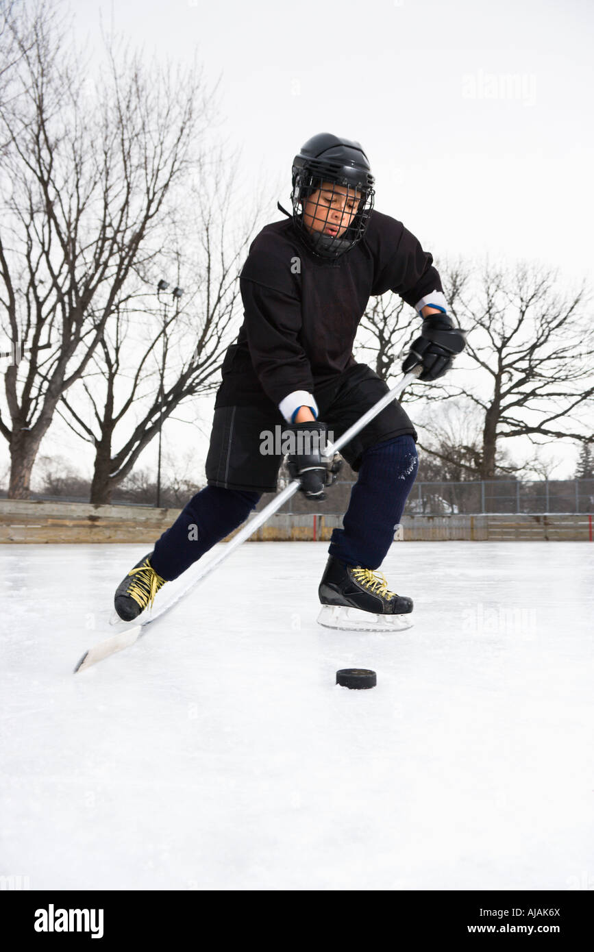 Подледный хоккей. Мальчик в хоккейной форме. Хоккей подо льдом. Подводный хоккей. Подледный хоккей шайба перемещается по нижней стороне слоя льда.