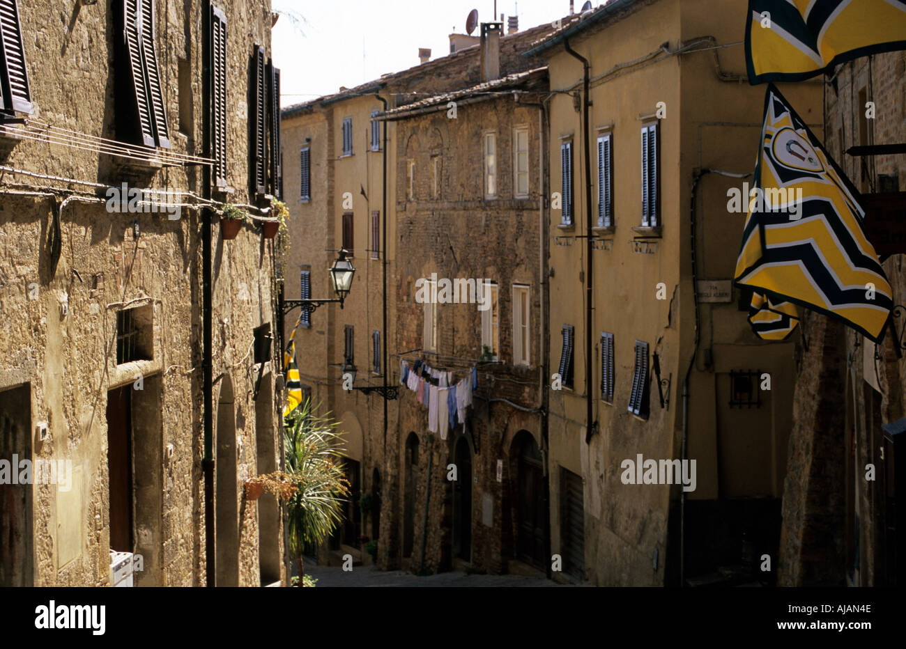 Volterra flags in narrow street in sunset Stock Photo