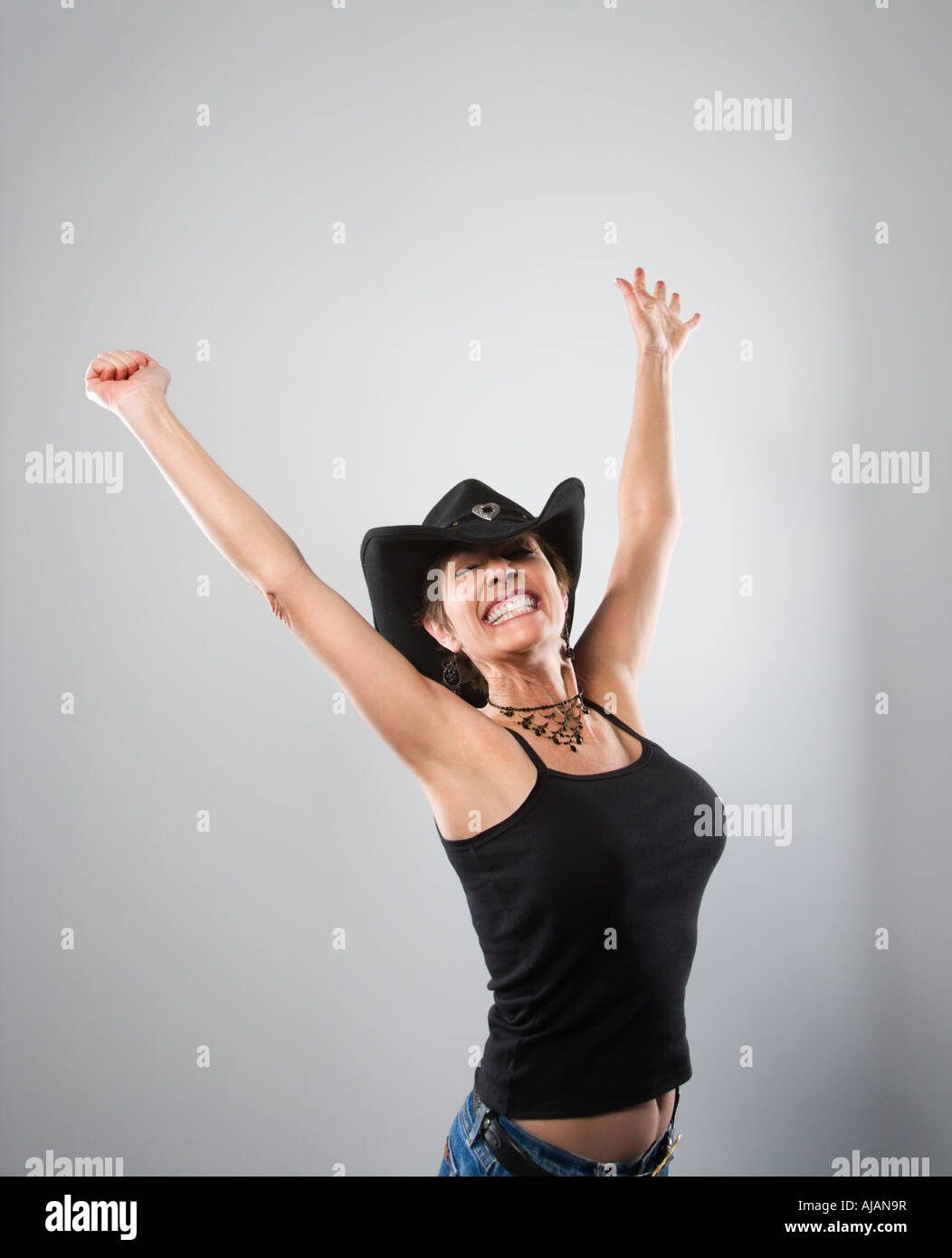 Portrait of woman smiling and holding arms up in air Stock Photo - Alamy
