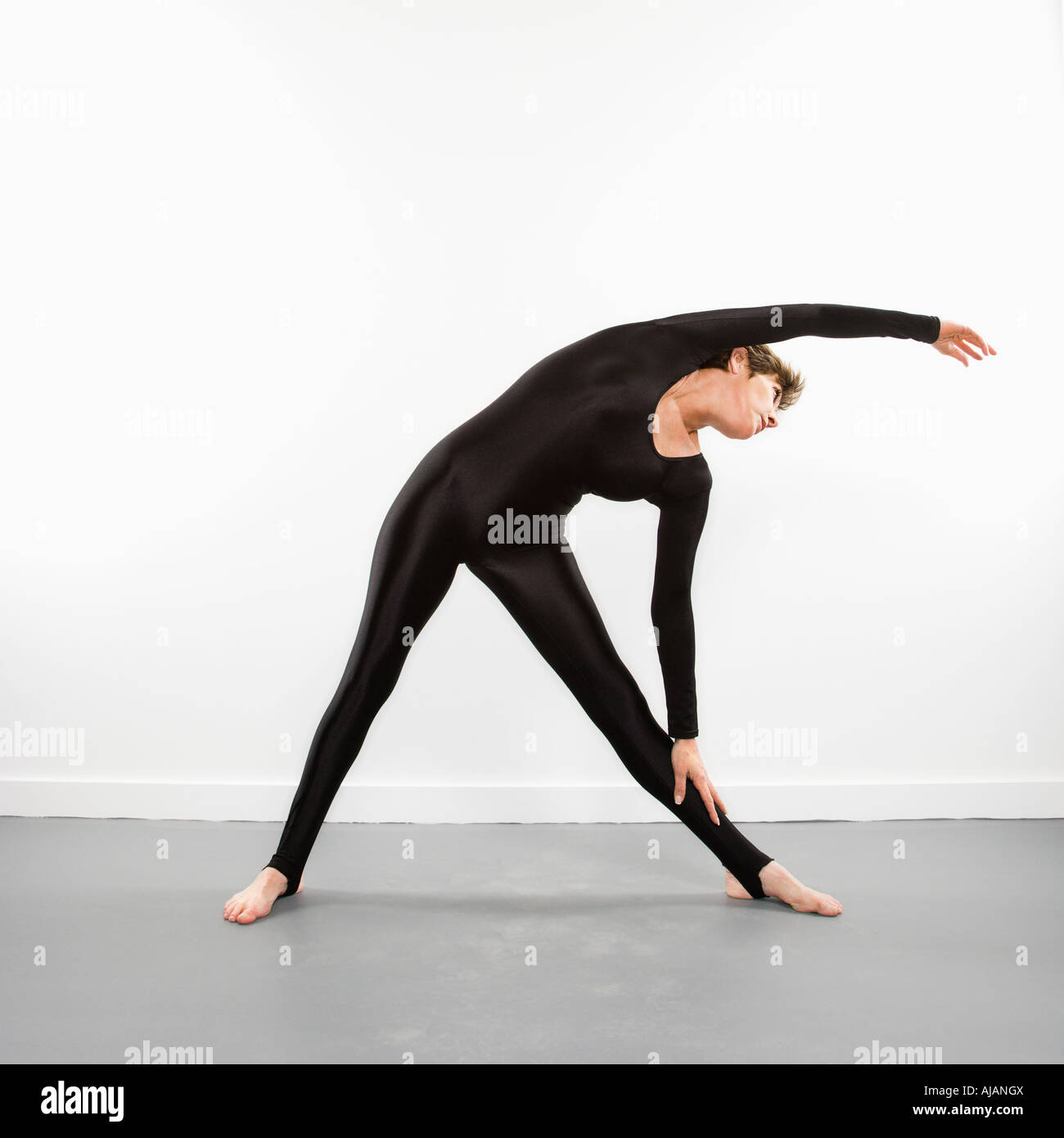 Portrait of pretty Caucasian woman in spandex bodysuit leaning and stretching to side Stock Photo