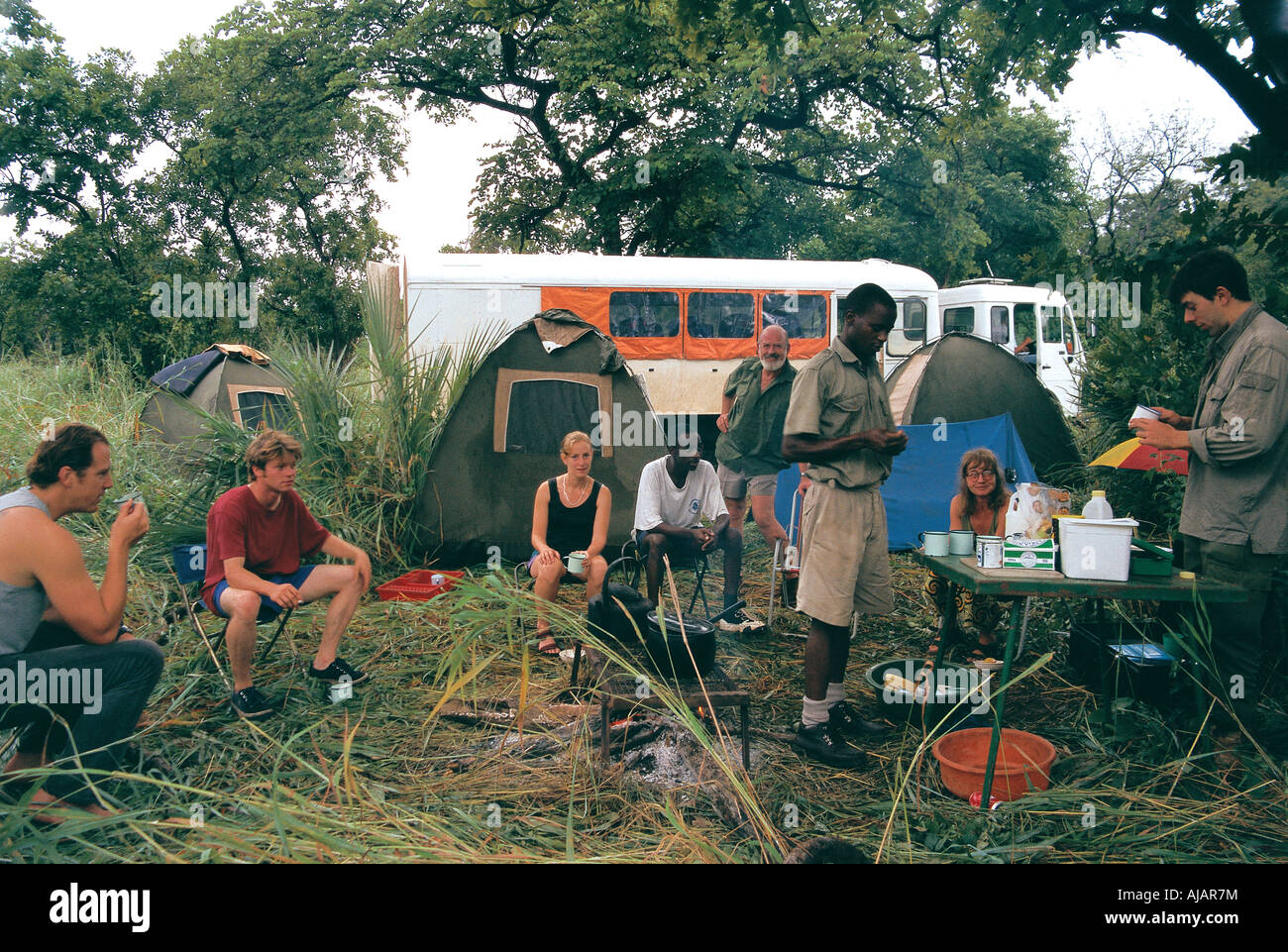 Overland truck safari mealtime for tourists at bush camp Zambia Stock Photo
