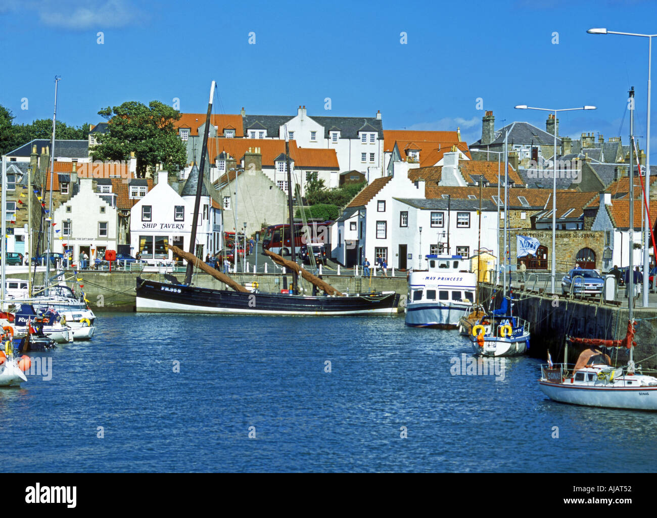 Fifie type fishing vessel Reaper tied up in Anstruther Harbour with the Scottish Fisheries Museum in the background Stock Photo