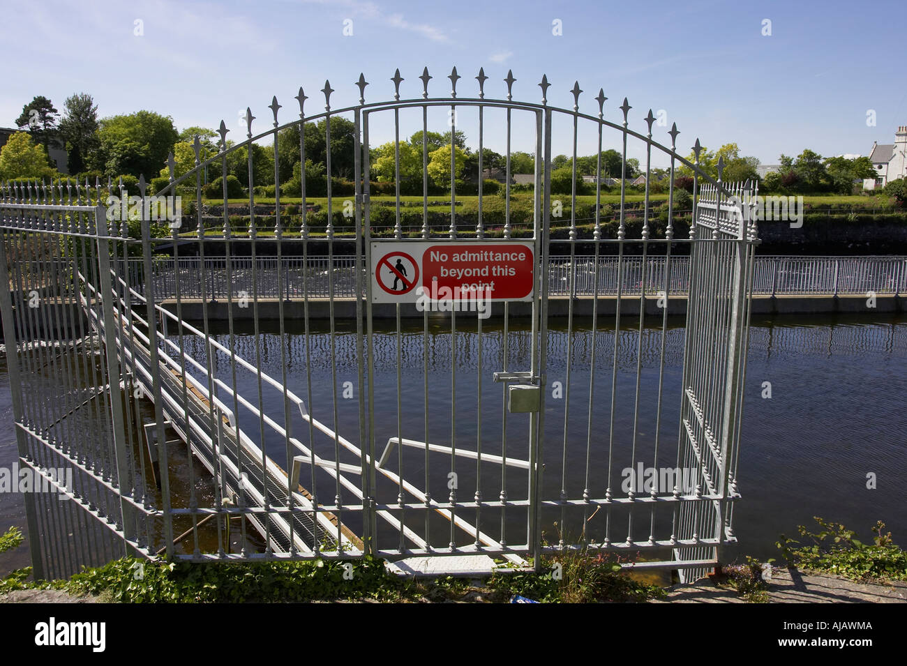 no admittance beyond this point sign on a metal spiked fence leading to floating pontoon in the Corrib river Stock Photo