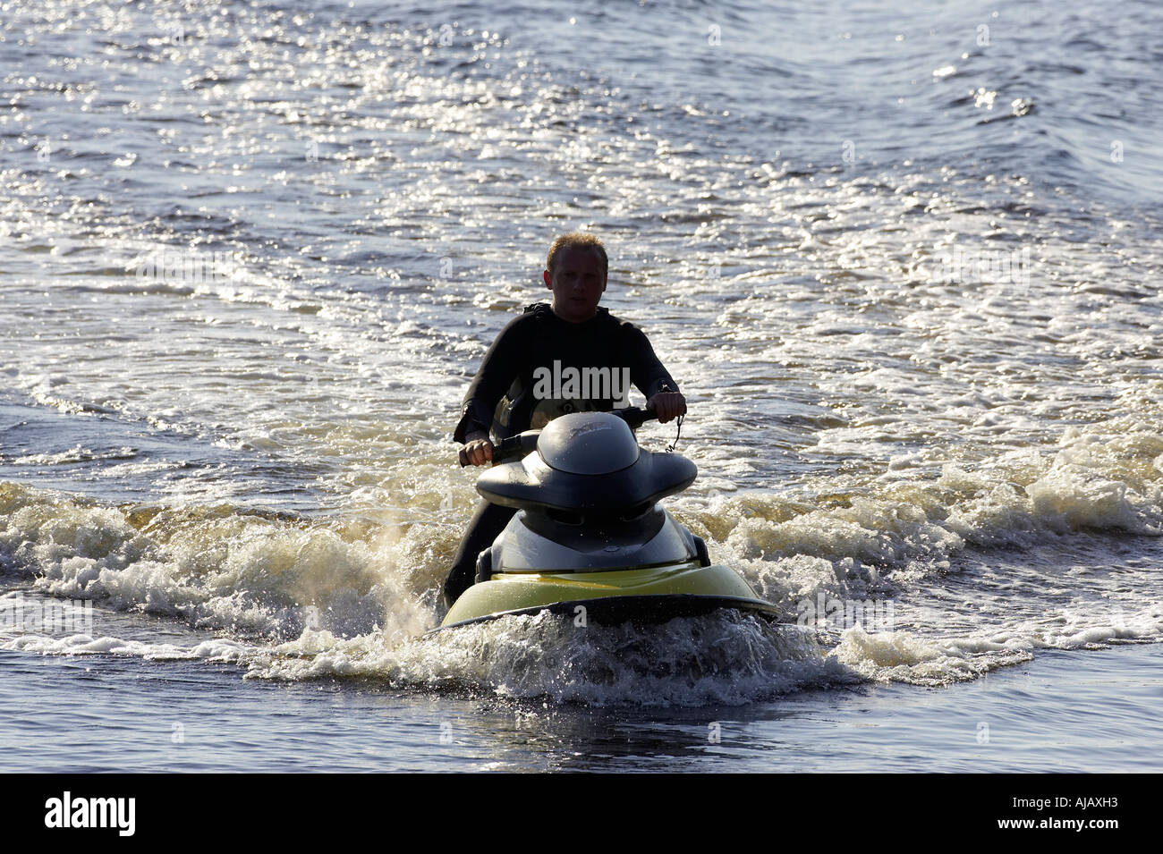 man in wetsuit on yellow bombardier seadoo rides into Bunbeg harbour