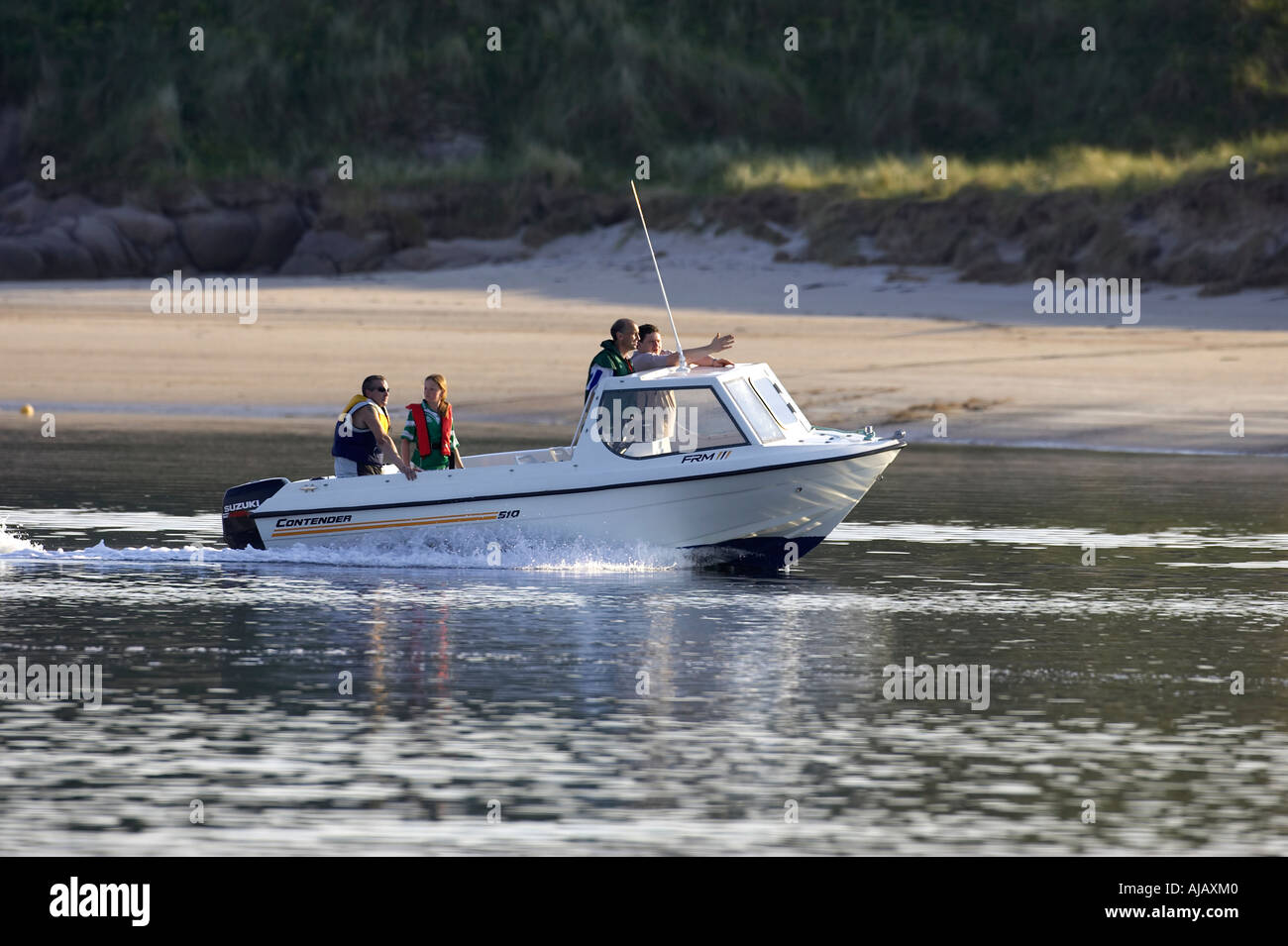 four people in lifejackets in small white pleasure fishing boat sails past bunbeg beach gweedore bay Stock Photo