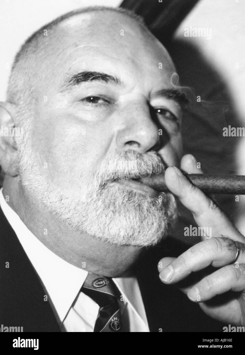 older man in suit smoking cigar Stock Photo
