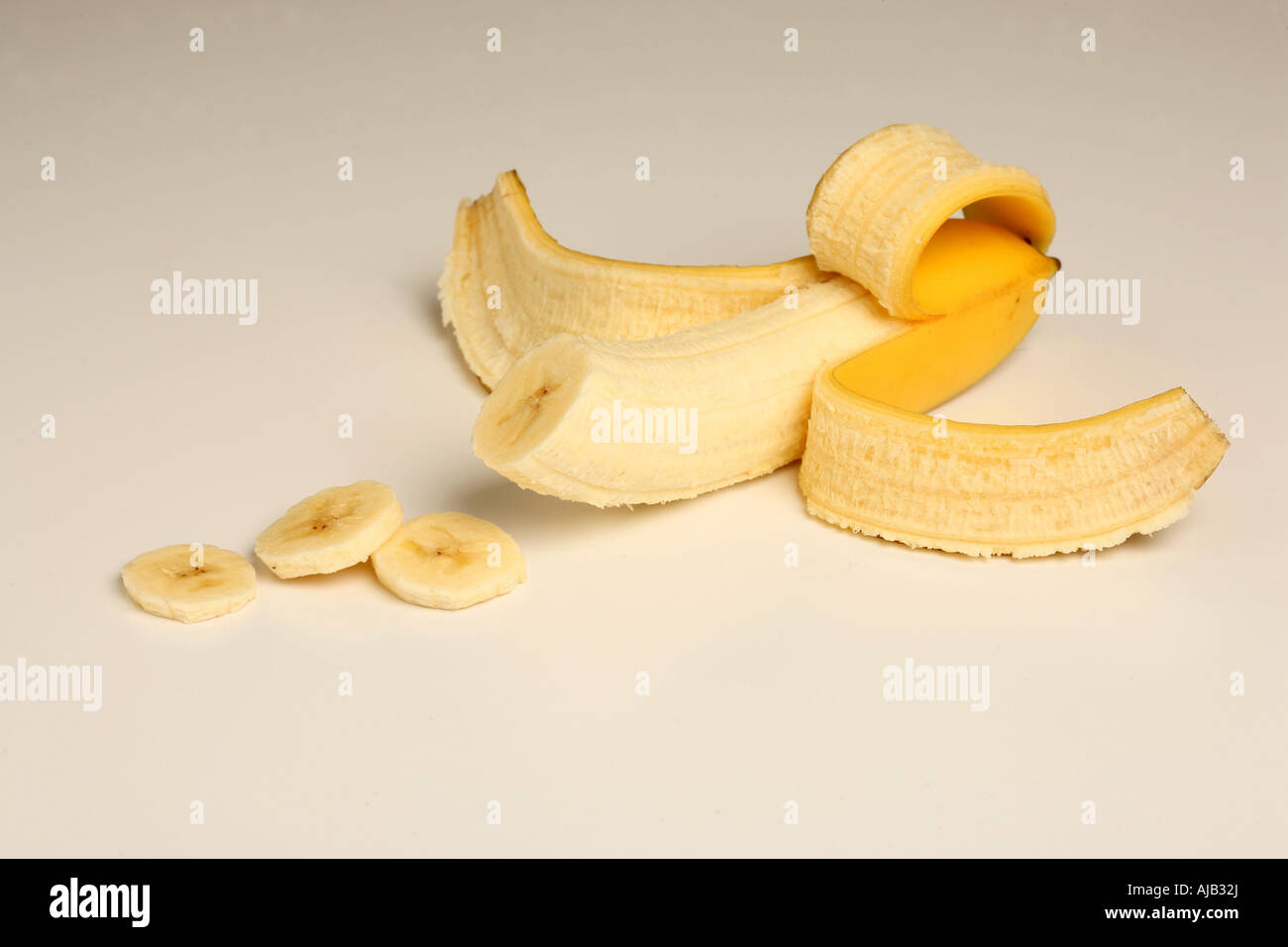 A cutout of a partly peeled banana Stock Photo