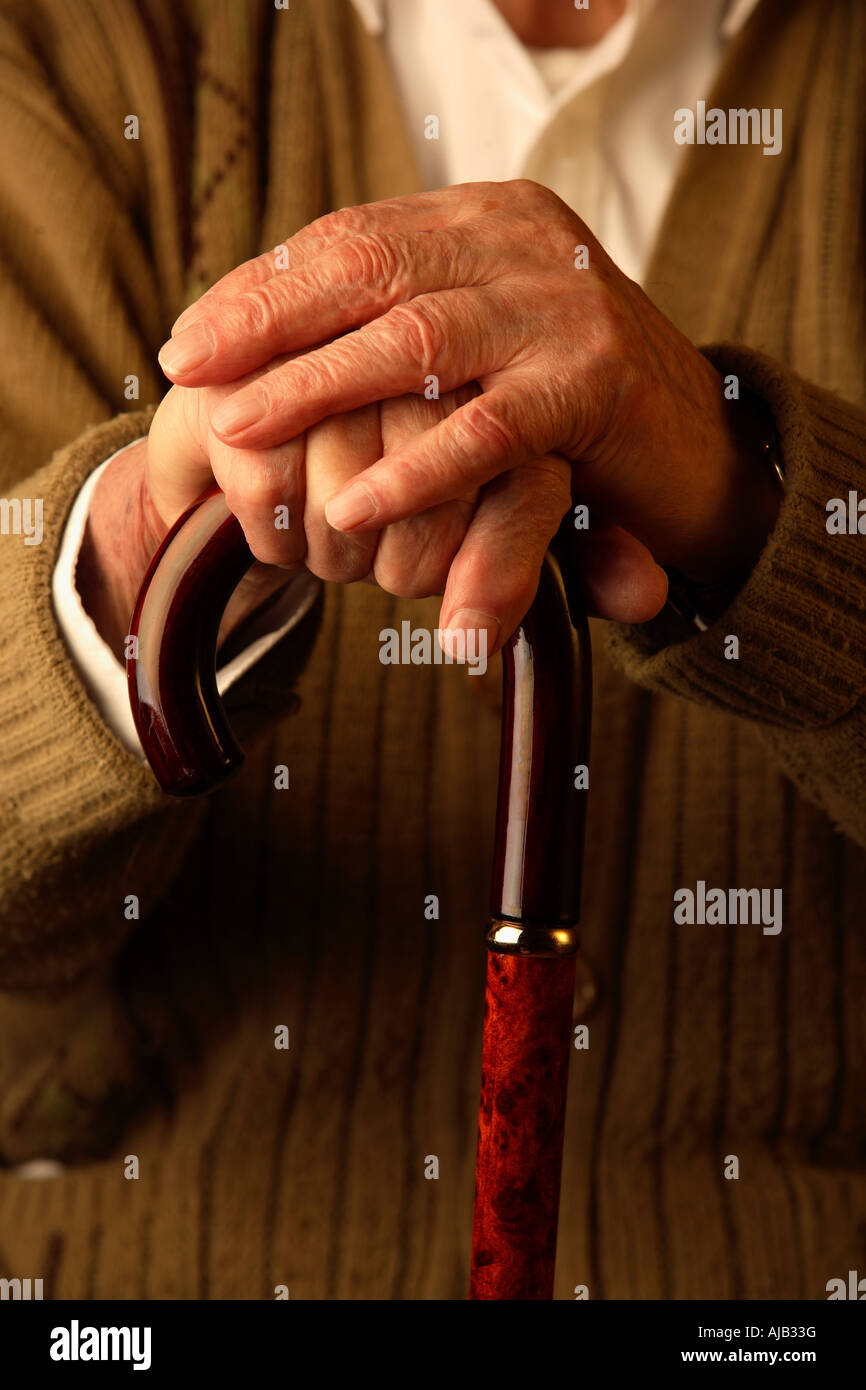 Old man with hands leaning on walking stick Stock Photo
