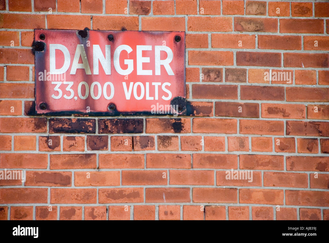 Warning sign outside an electricity substation saying 'Danger, 33,000 volts' Stock Photo
