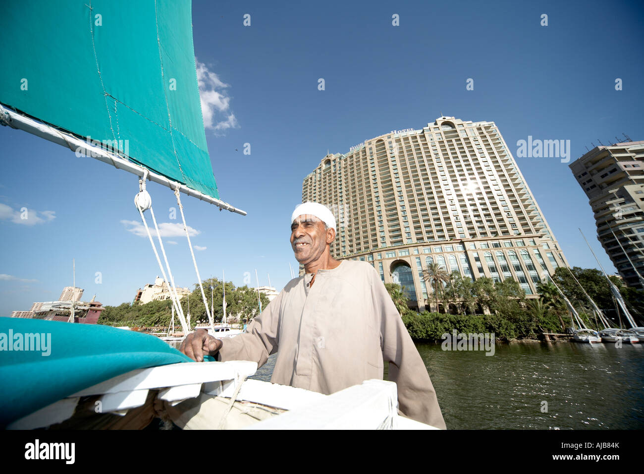Man sailing felucca sailing boat in front of Four Seasons Hotel Cairo Egypt Africa Stock Photo