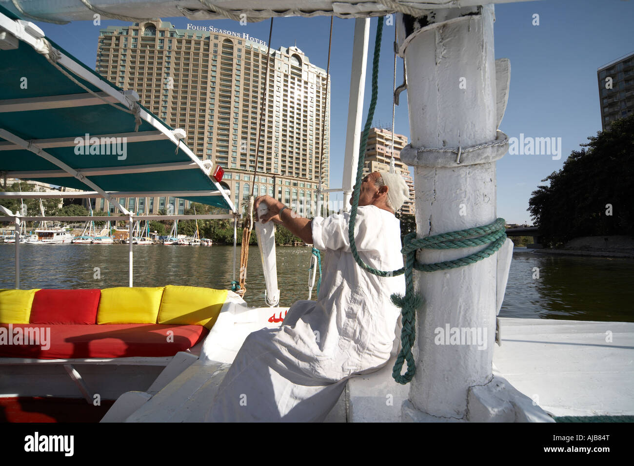 Egyptian boat man in traditional galibeya robe rowing Felucca sailing boat Cairo Egypt Africa Stock Photo