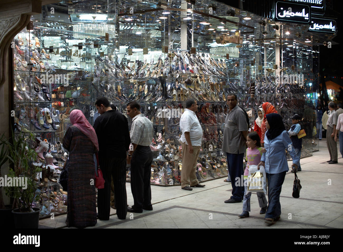 People strollig in fron of smart shops and boutiques in evening or