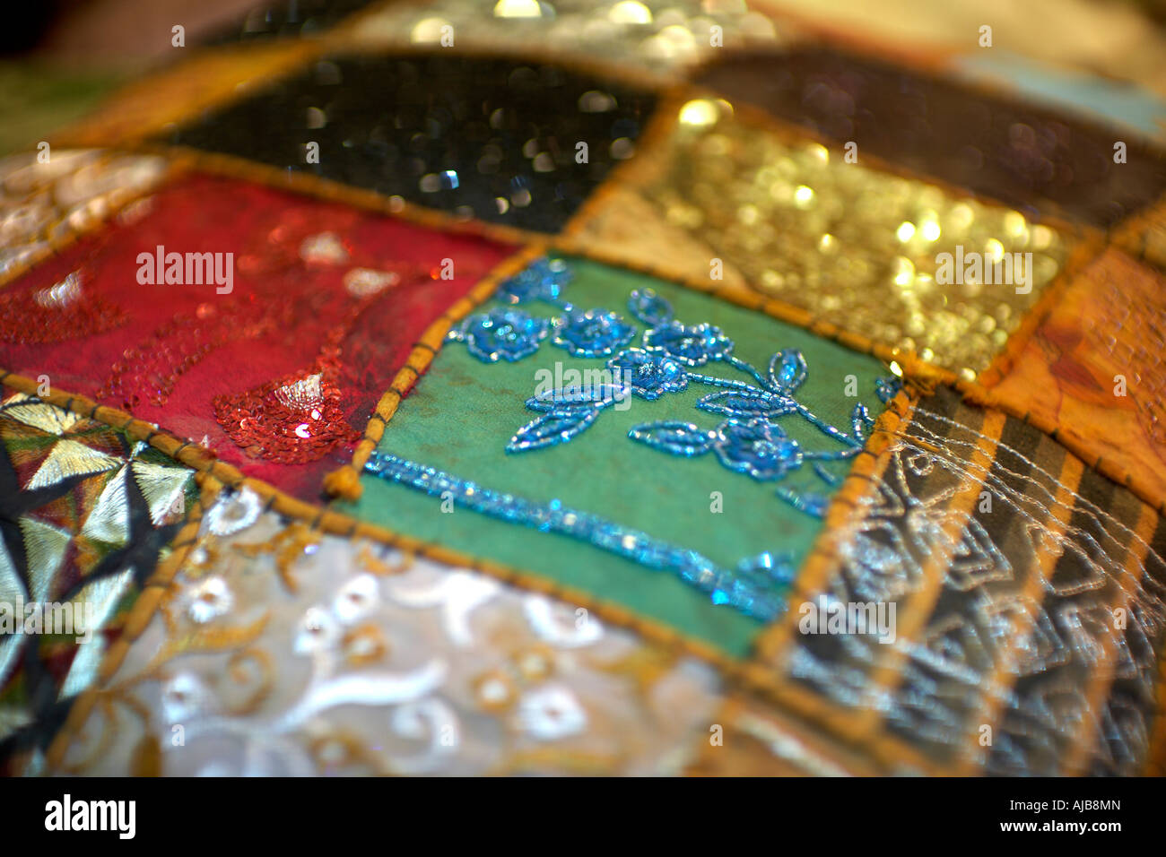 Abstract detail image of fabrics or quilted embroidered material on display at night market or souk stall in evening in Mohandi Stock Photo