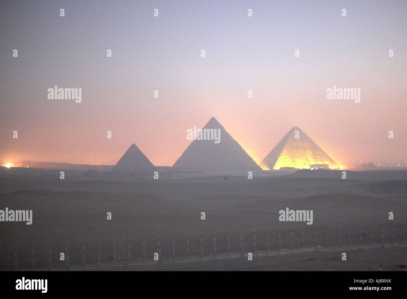 Early morning dawn twilight view of illuminated pyramids in Giza Cairo ...