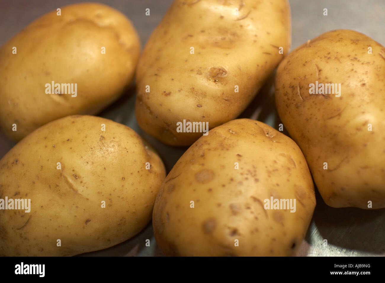 Raw uncooked potatoes or potatoes for baking on a metal tray Stock Photo