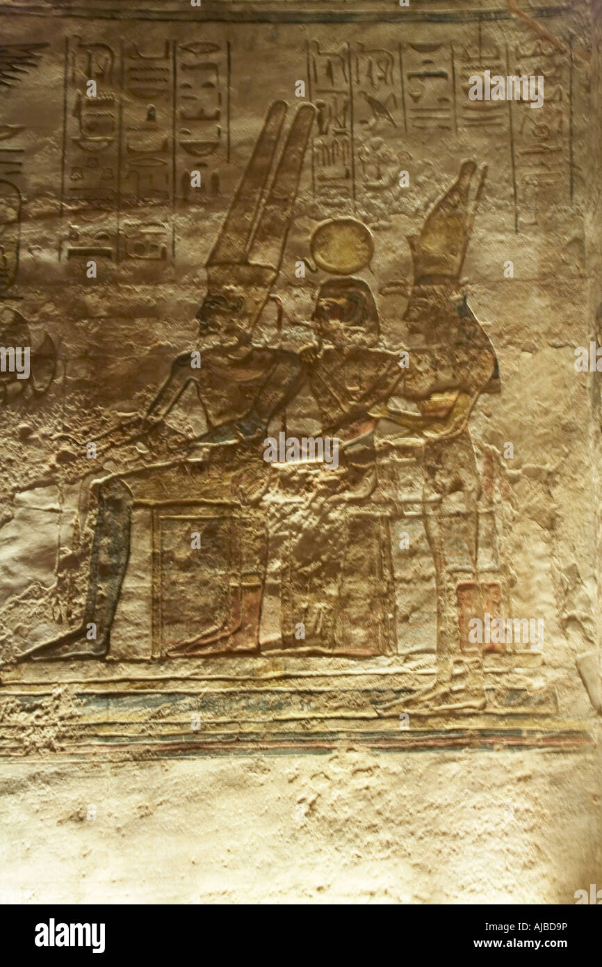 Wall relief carving of holy triad of Luxor Thebes with Amun Ra sun god Ramsis II as Khonso moon god and Mut mother of gods Egypt Stock Photo