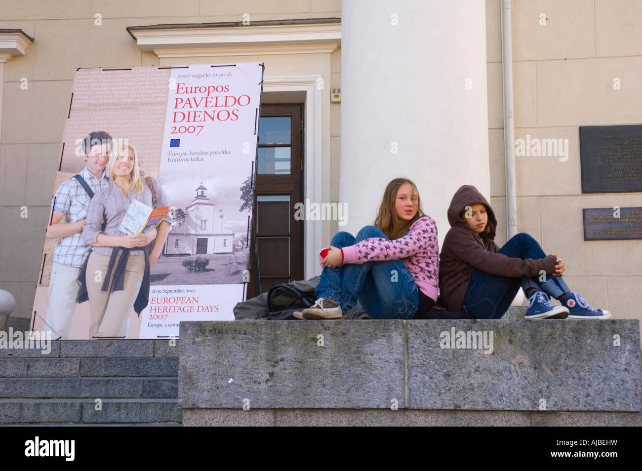 Girls sitting at Town Hall central Vilnius Lithuania Stock Photo