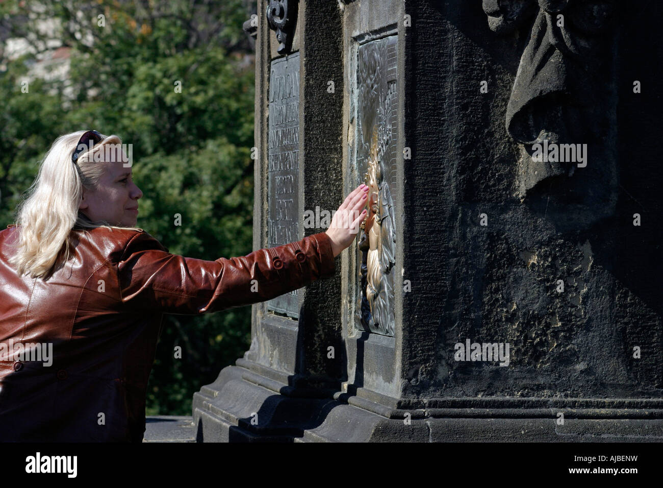 Touching the plaque for good luck beneath the statue of St John of
