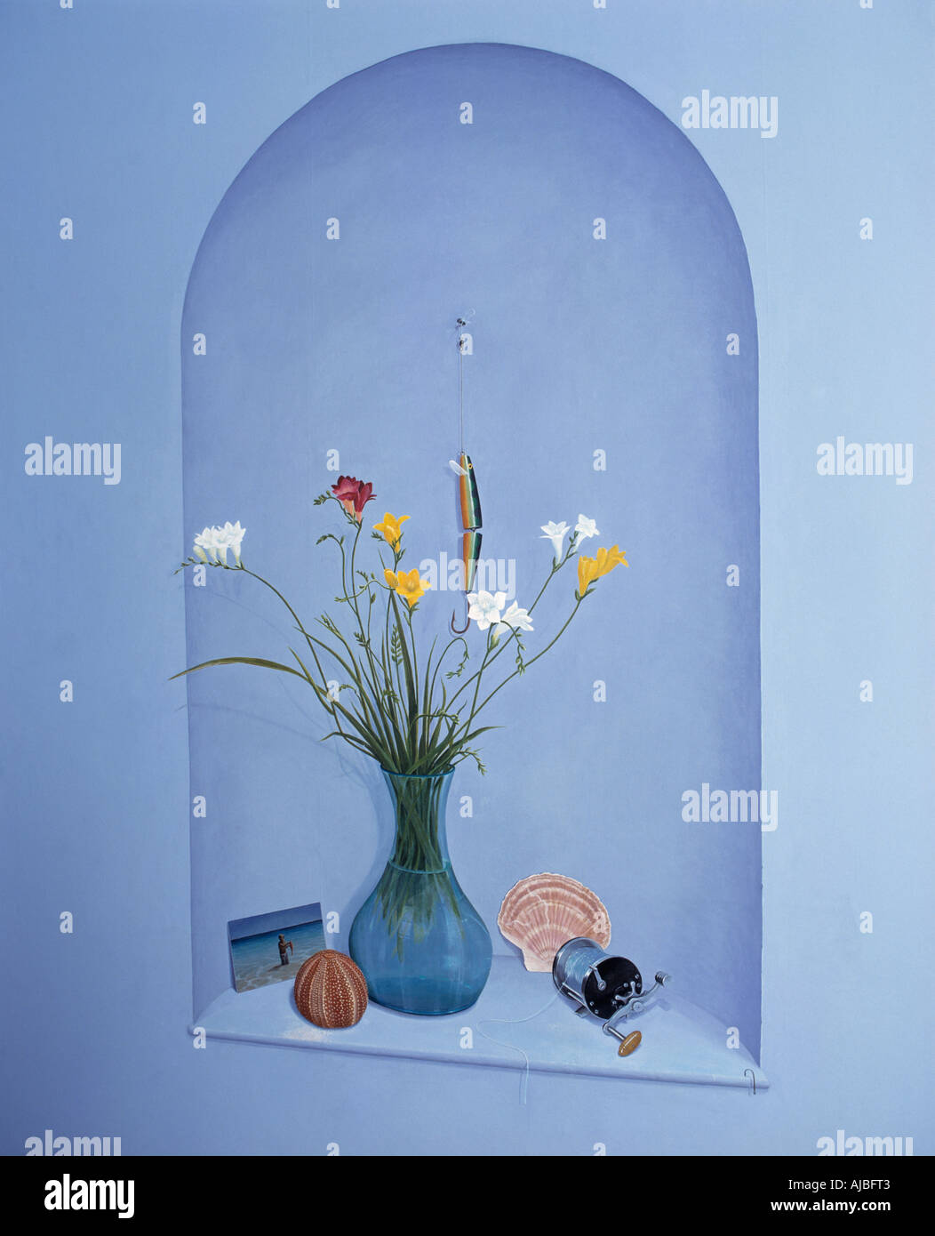Close-up of vase of flowers and seashells in trompe l-oiel paint effect alcove on blue wall Stock Photo