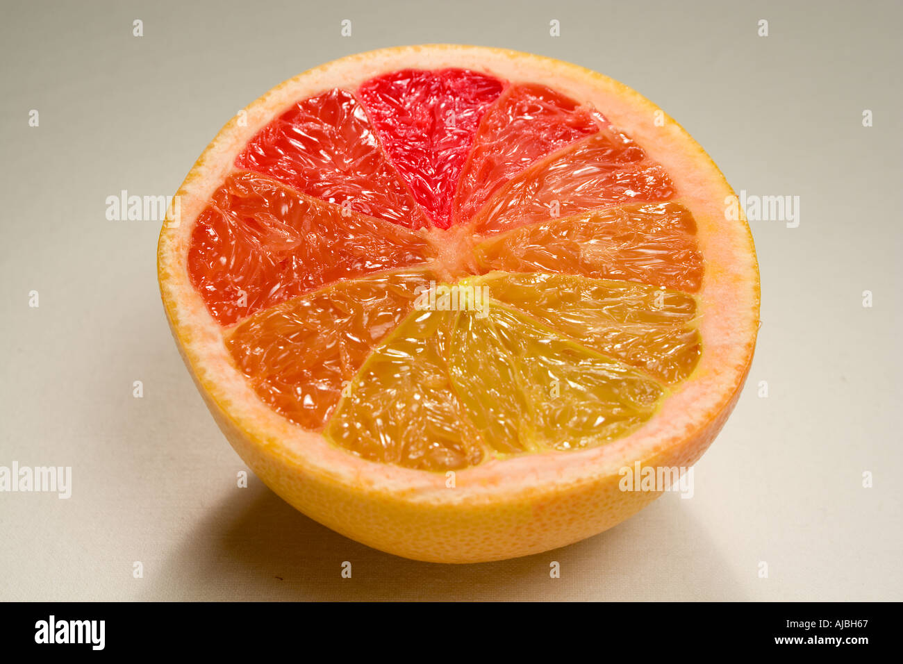 A grapefruit with multicoloured segments Stock Photo