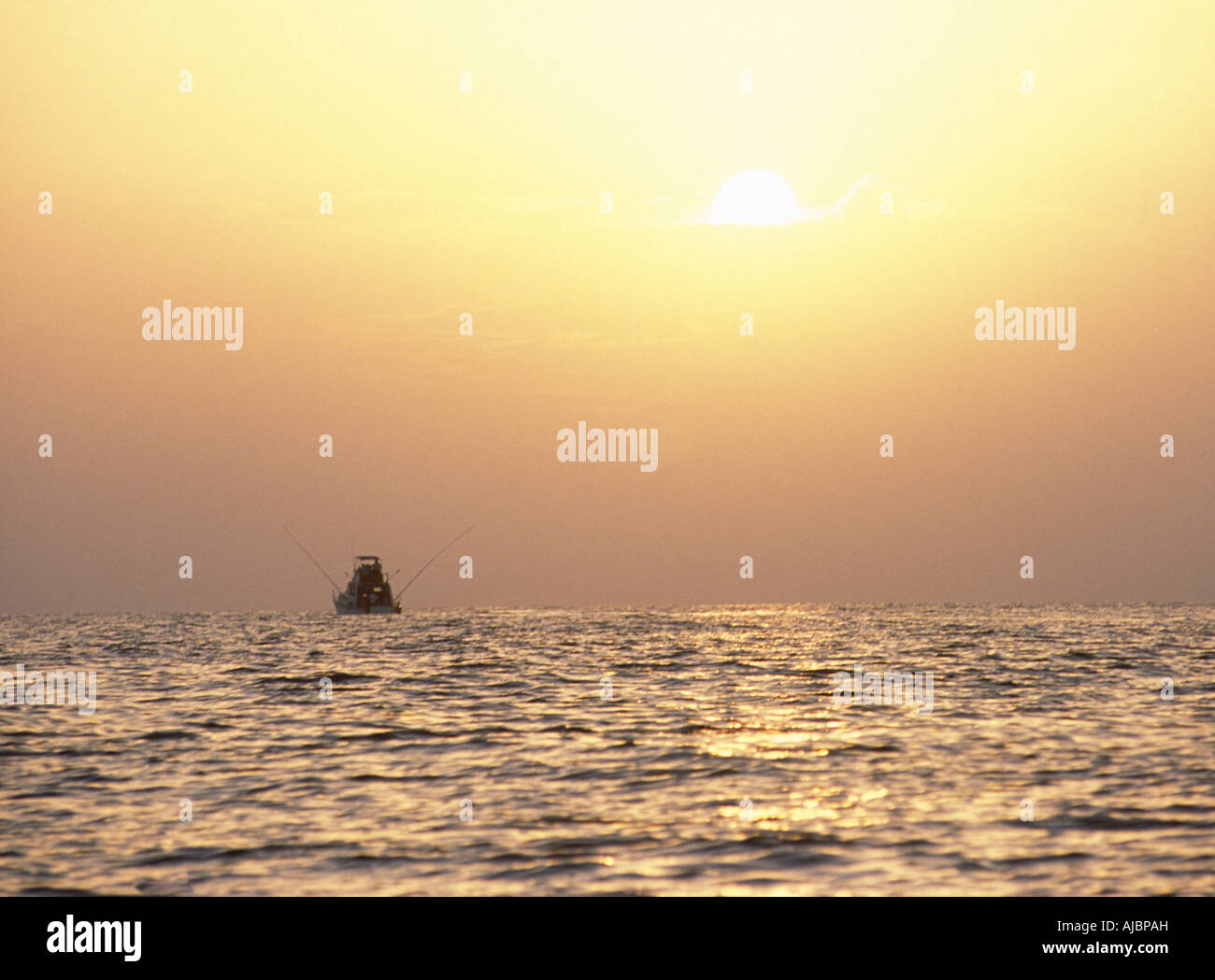 Silhouette of a Fishing Boat at Sea at Sunset Stock Photo - Alamy