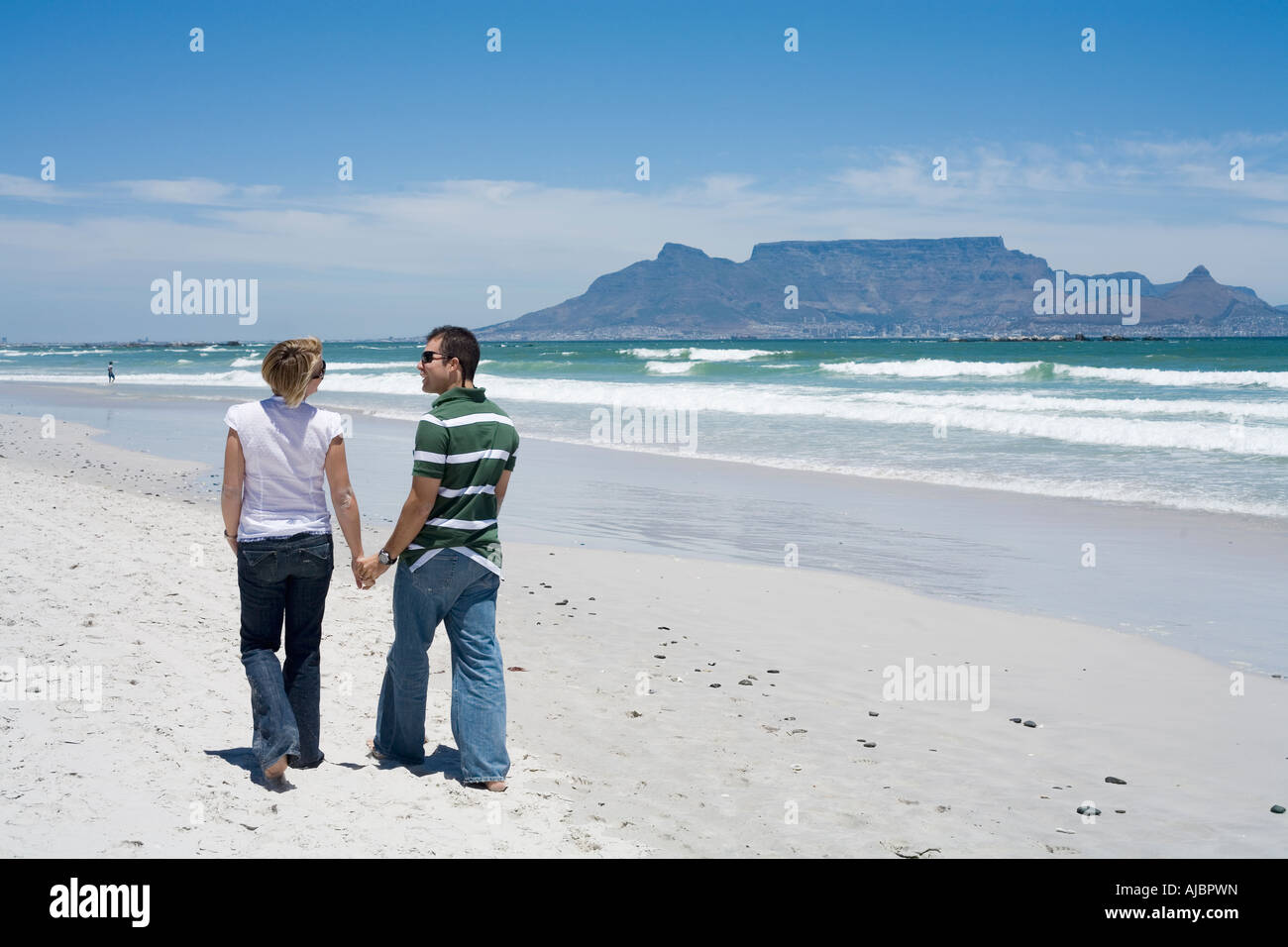 Couple Walking Hand in Hand on the Beachfront Stock Photo