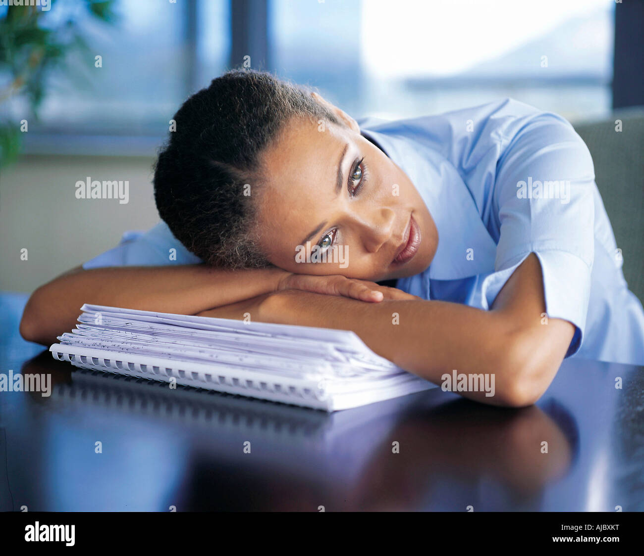 African Businesswoman Resting on Paperwork Stock Photo