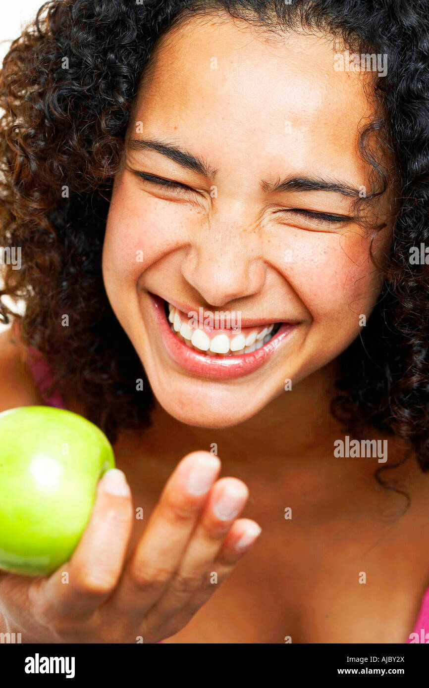 Portrait of an African Woman Holding a Fresh Apple, Laughing Stock Photo