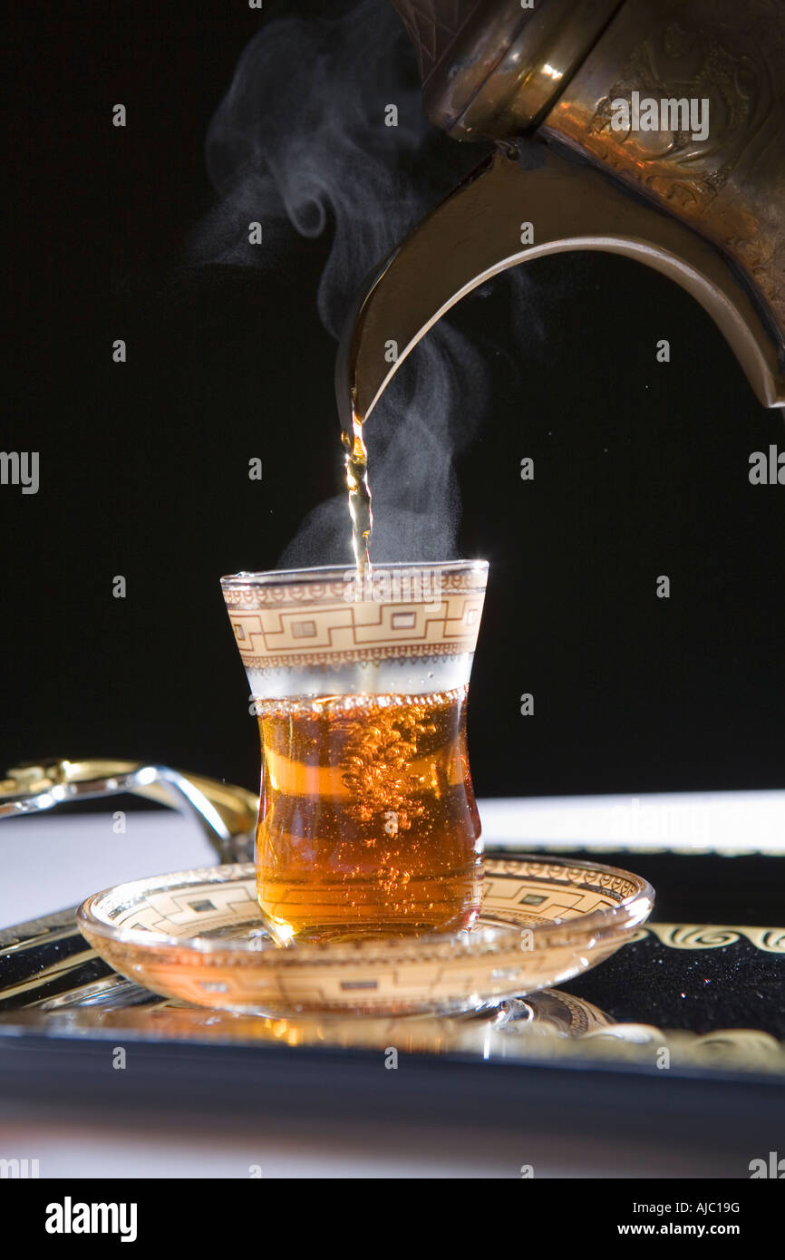 Pouring Steamy Hot Tea with Dallah into Cup Stock Photo