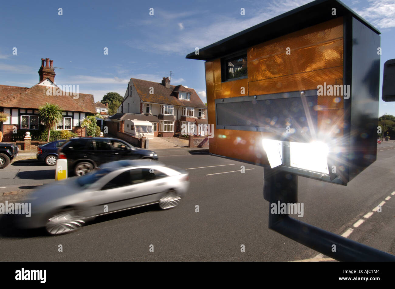 Speed camera flash going off as a speeding car passes Stock Photo