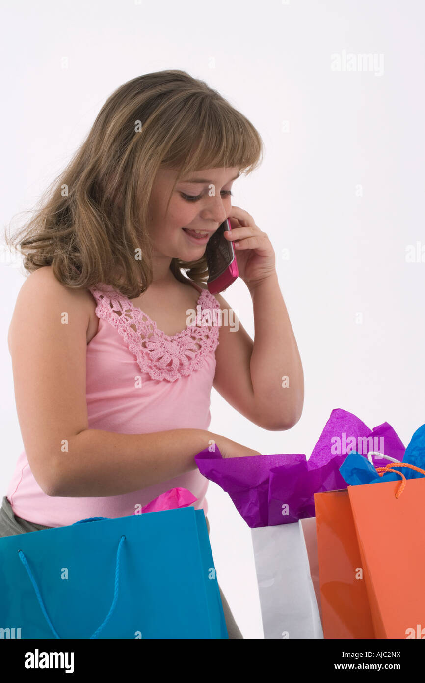 Young Girl on a Cell Phone Looking into a Paper Bag Stock Photo