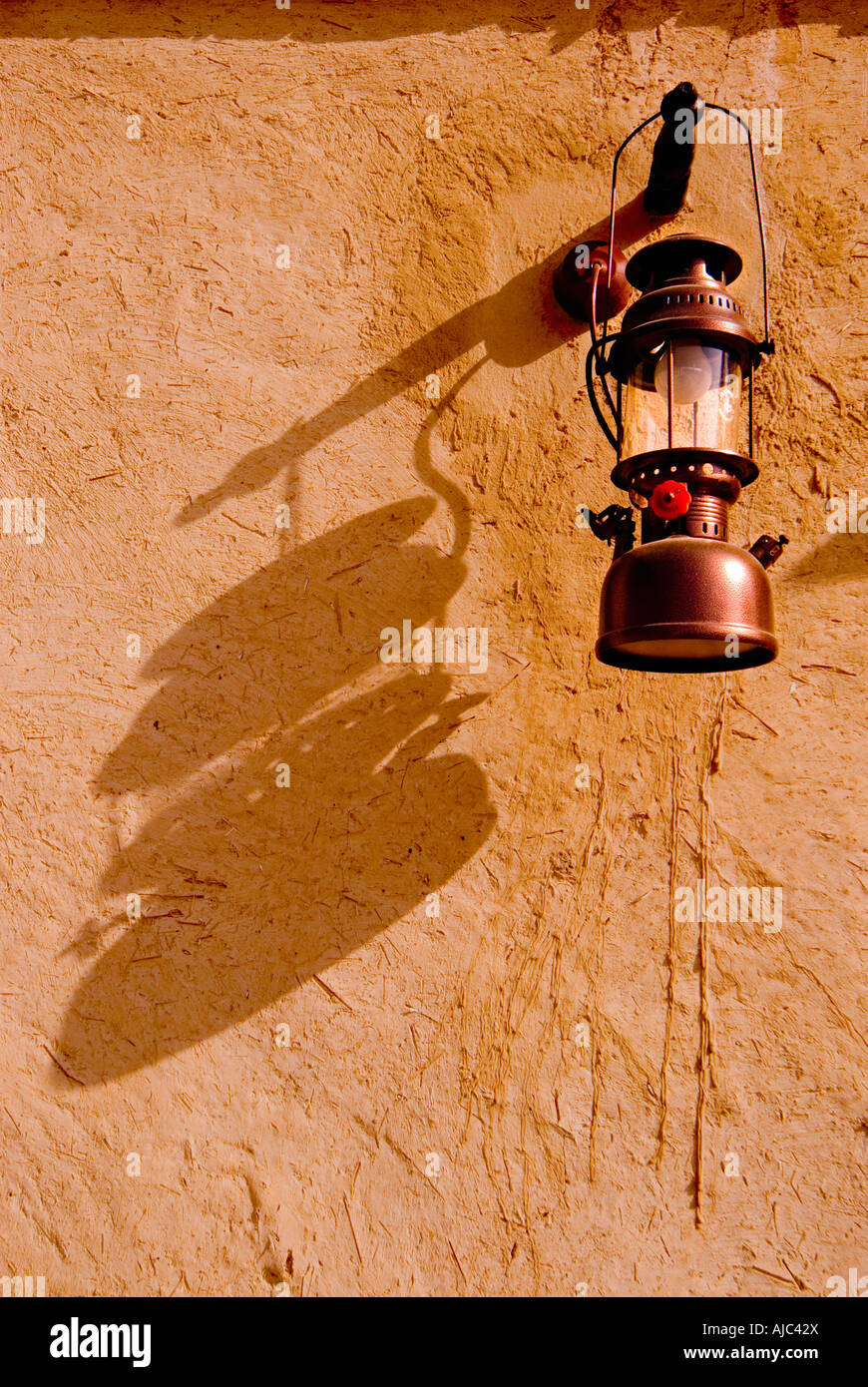 An Arabic Lantern relfecting it's Shadow on the Wall of a Room Stock Photo