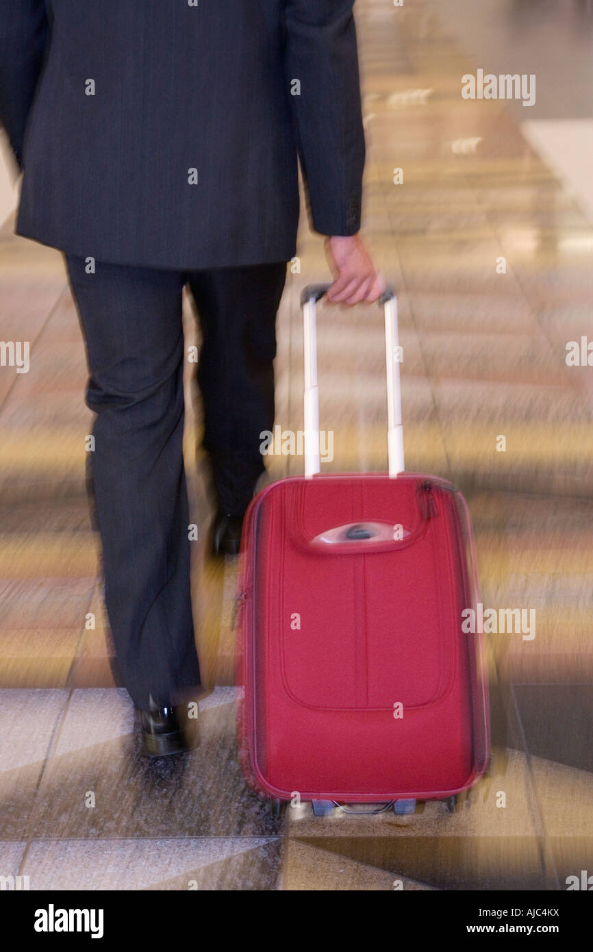 Rear View of a Businessman Pulling a Suitcase Blurred Motion Stock