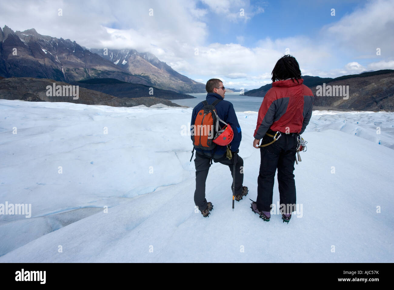Rear View of Two Hikers Admiring the View From Glacier Grey Stock Photo