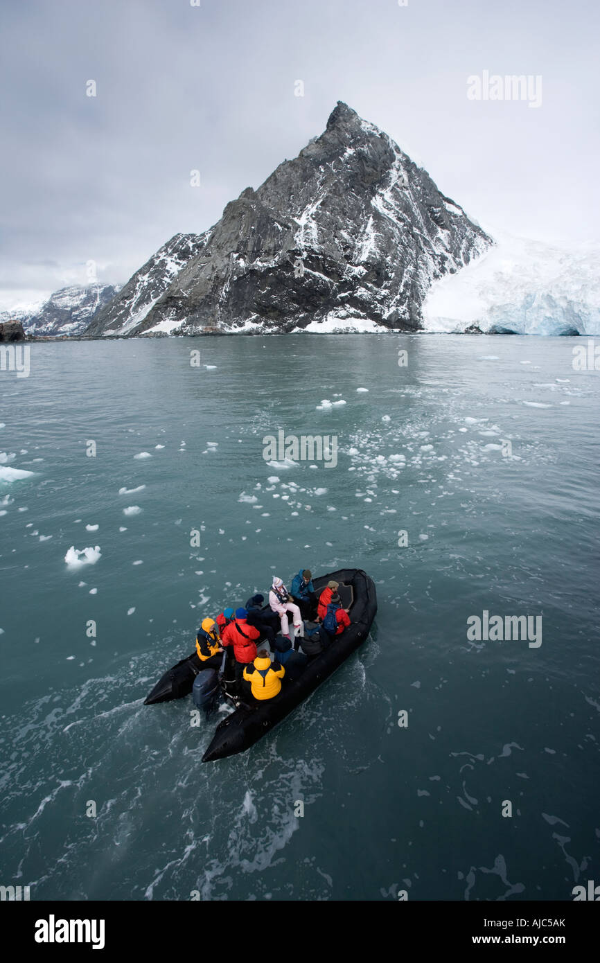 Tourists in a Zodiac with Ice Covered Shoreline Stock Photo