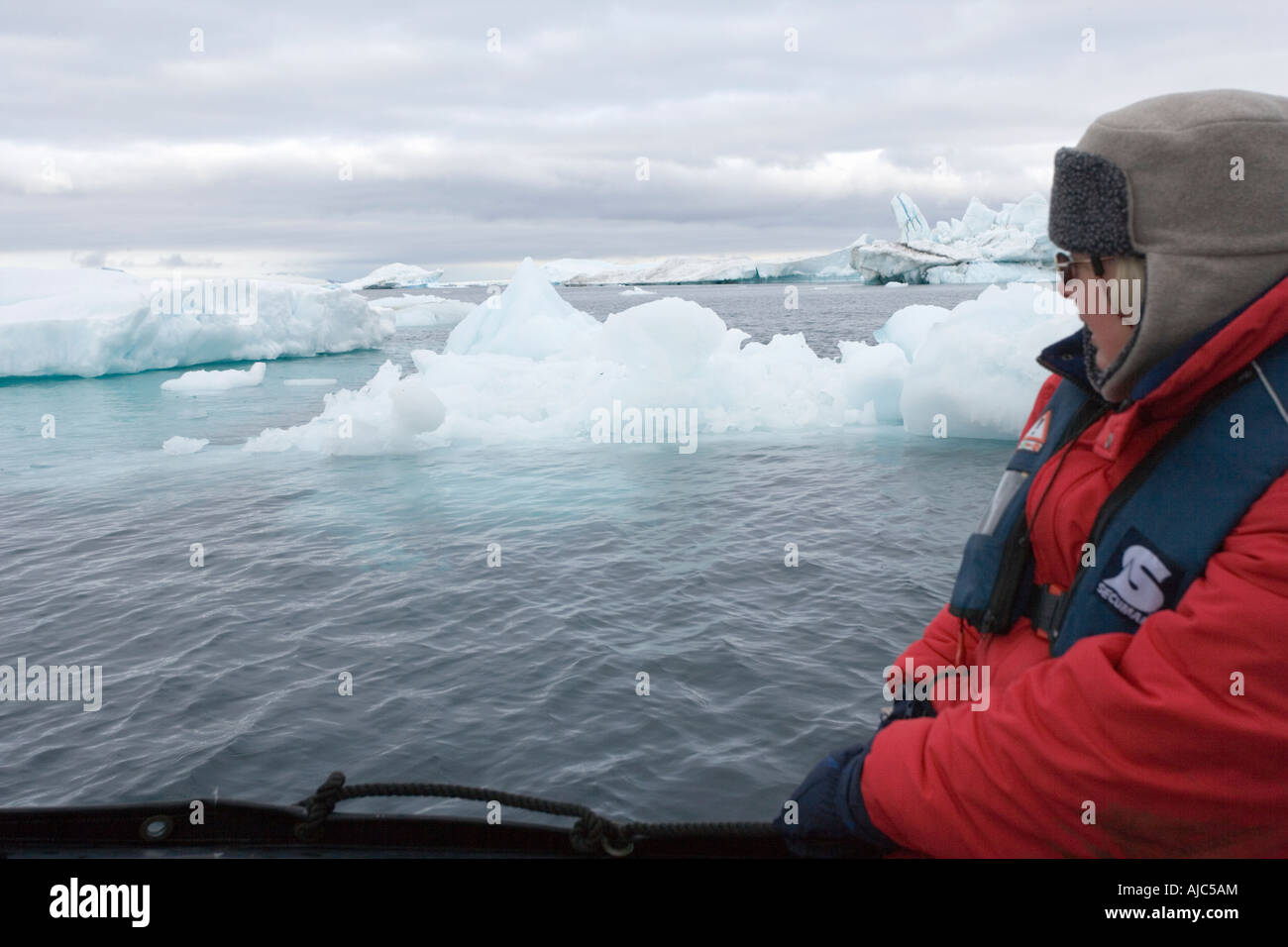 Tourist in a Zodiac Viewing Ice Covered Shoreline Stock Photo