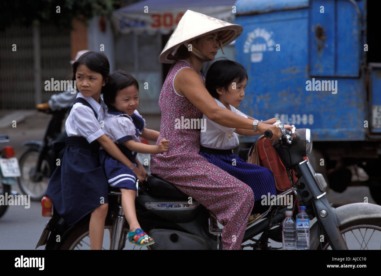 Urban transport mother and 3 children on a motorcycle Ho Chi Minh City Saigon Stock Photo