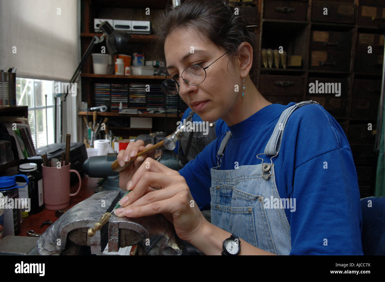 A craftsperson chases a brass finial at P E Guerin Inc fine hardware family business in Greenwich Village in NYC Stock Photo