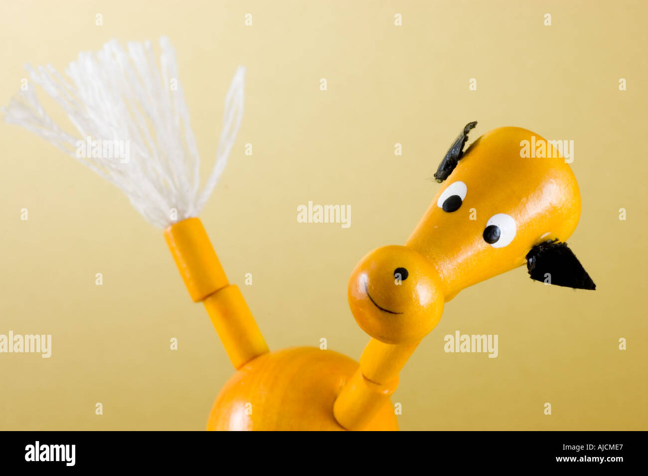 Picture of a traditional wooden toy horse against a gold background Stock Photo