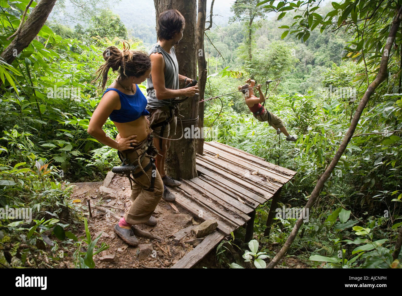 Spanish tourists zip lining from tree house to a landing platform at The Gibbon Experience near Huay Xai on Mekong river in Laos Stock Photo