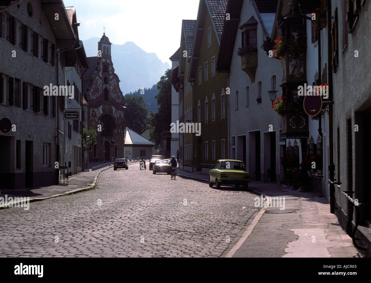 Backlit cobbles and Sunday morning traffic in a street in Fuessen Bavaria Taken circa 1979 Stock Photo